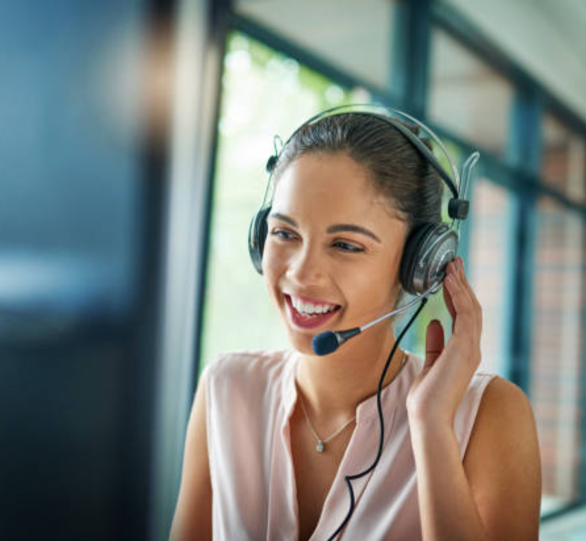 a woman wearing a headset is smiling while talking on a computer.